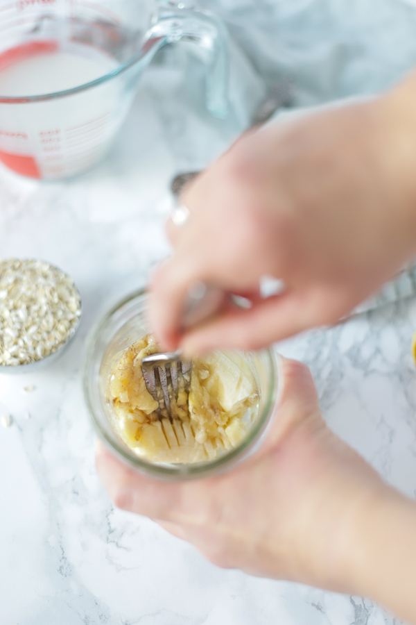mashing a banana with a fork in a mason jar