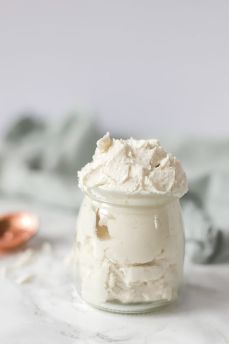 dairy free vegan whipped cream in a glass container with a cobber spoon in the background