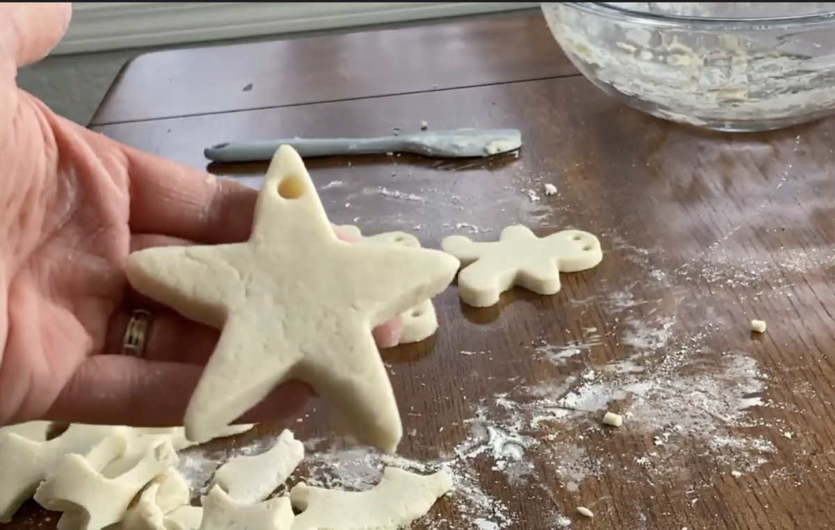 hand showing star salt dough ornament with a hole that is ready for baking