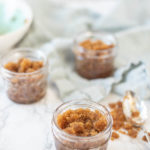 jars of homemade brown sugar scrub with a blue napkin in the background