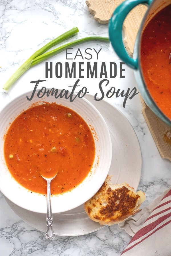tomato soup in a bowl with sourdough grilled cheese to the right. Turquoise dutch oven with more soup to the right.