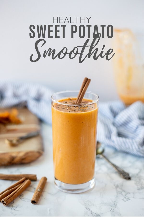 sweet potato smoothie in a tall glass with a cinnamon stick . Ingredients surround smoothie