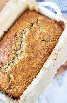 overhead close up photo of sourdough banana bread with a white and blue towel in the background
