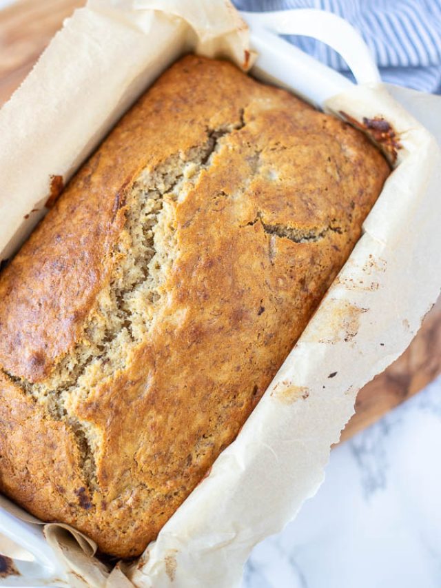 overhead close up photo of sourdough banana bread with a white and blue towel in the background