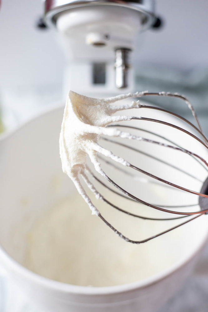 stand mixer whisk with whipped body butter forming a stiff peak