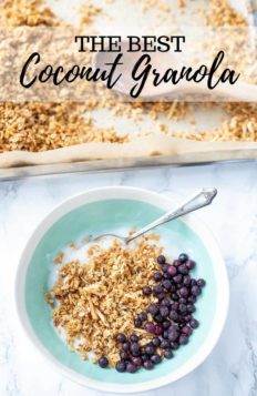 coconut granola in a bowl with yogurt and frozen blueberries. Pan of baked oatmeal in the background