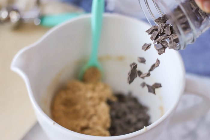 adding chocolate chips to oatmeal cookie dough