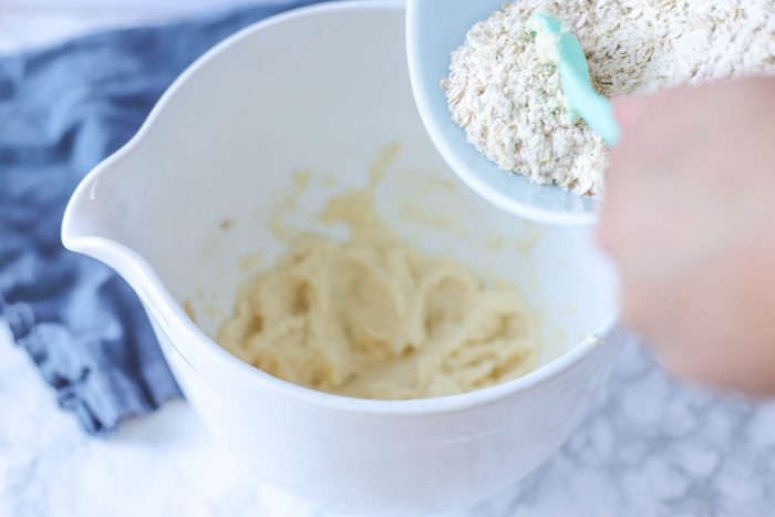 oats being added to whipped butter and sugar