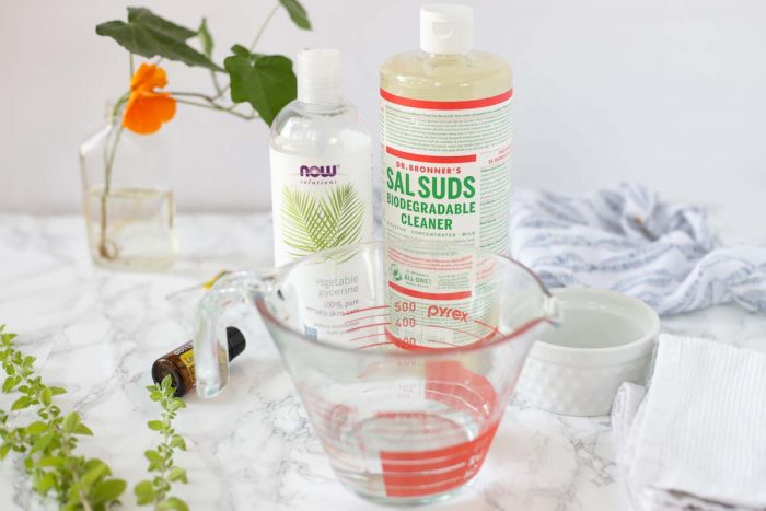 homemade dish soap ingredients on a marble countertop with ivy in the background