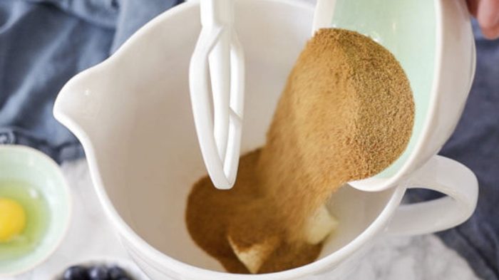 coconut sugar being added to butter in a stand mixer