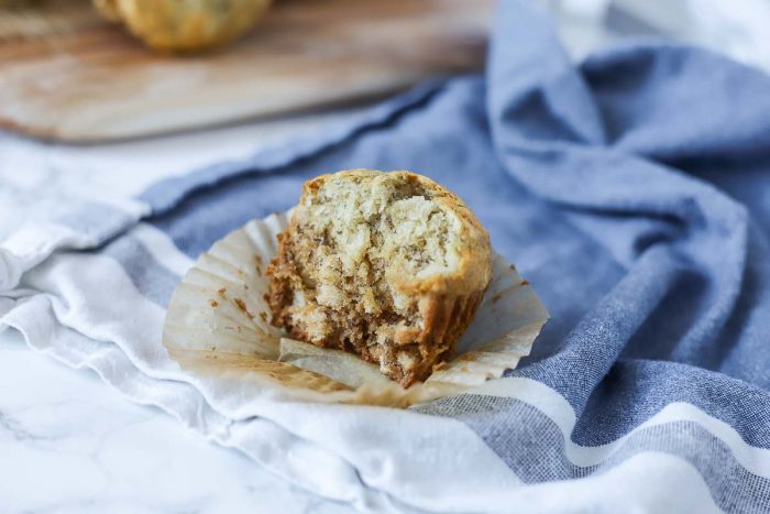 sourdough banana muffin with a bite taken out on a blue and white towel