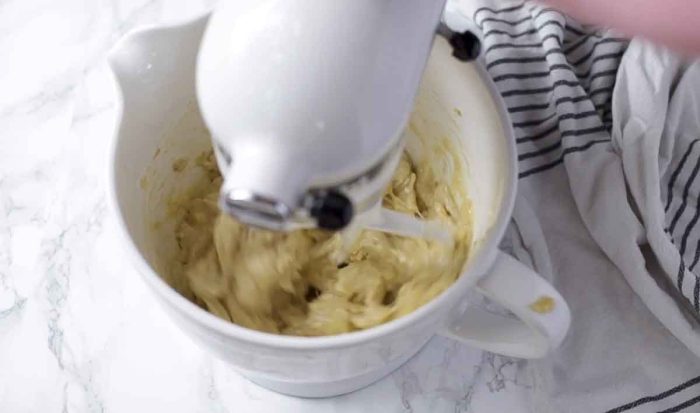 stand mixer mixing up sourdough banana bread batter in a white bowl