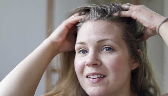 a woman rubbing a sugar scalp scrub onto her scalp