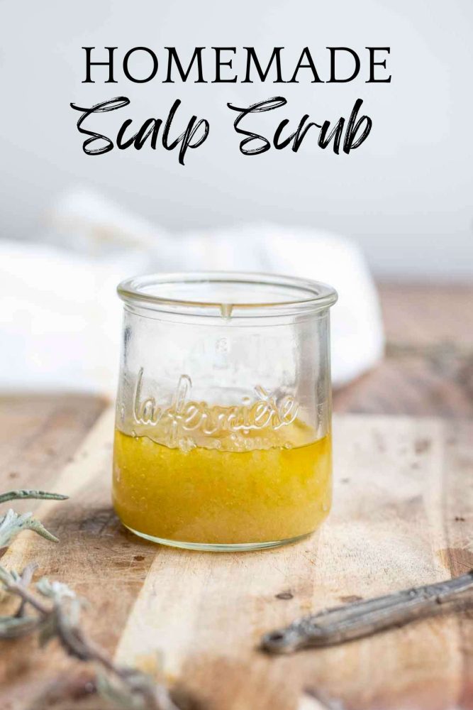 glass jar full of homemade scalp scrub on a wooden cutting board with a towel in the background