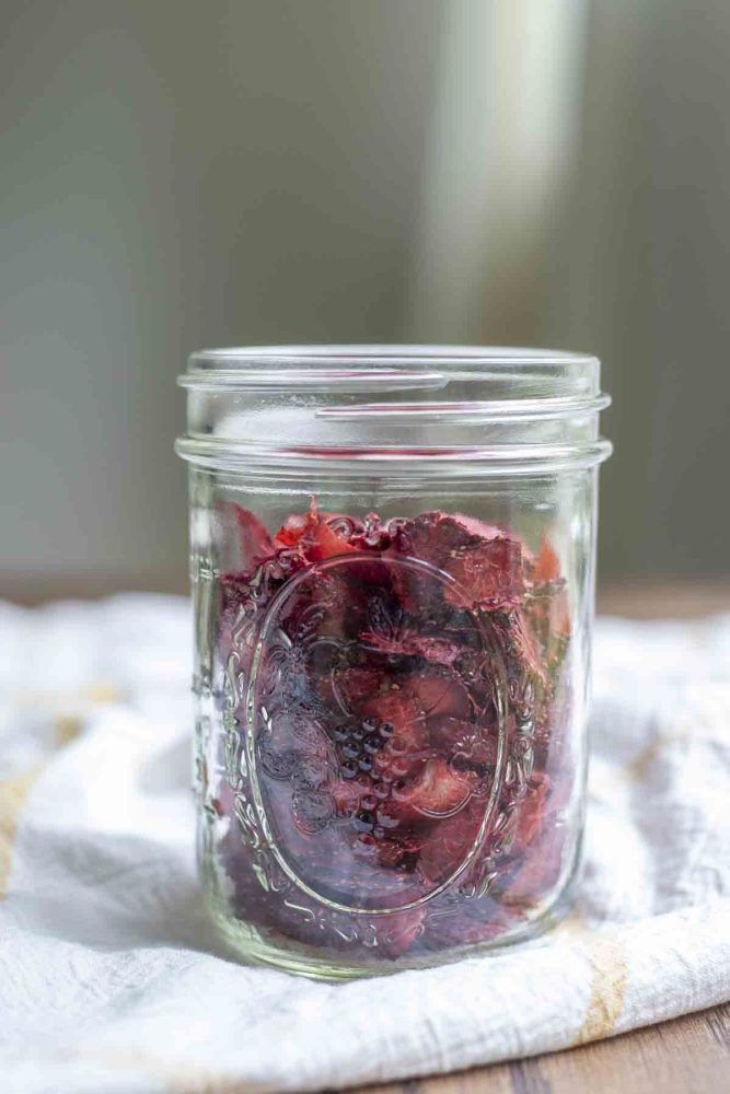 jar of dehydrated strawberries on a white and yellow checked towel