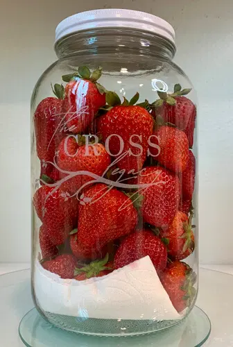 strawberries in a jar with paper towel at the bottom