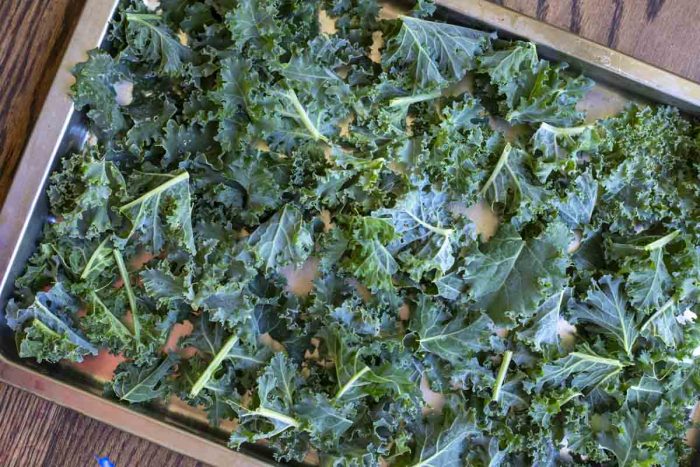 frozen kale on a cookie sheet on a wood table