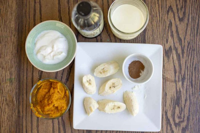 pureed pumpkin, yogurt, vanilla extract, milk, pumpkin spice, and frozen banana in plates and jars