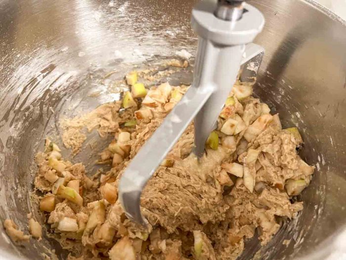 diced apples added to muffin batter in a stand mixer with paddle attatchment