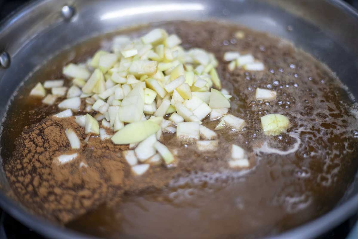 apples added to sugar, water, and cinnamon mixture.