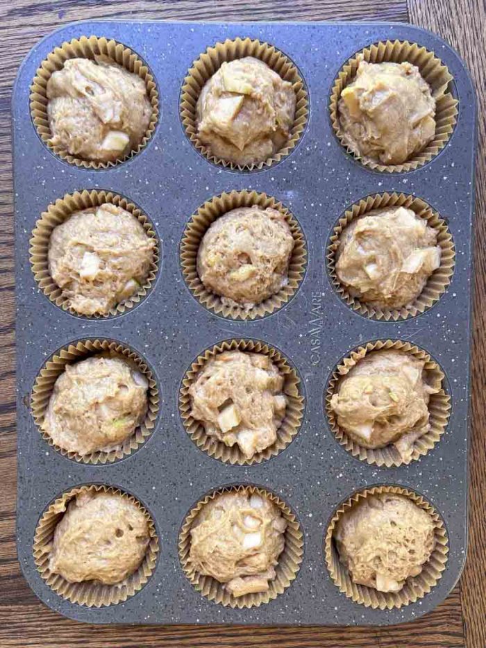 sourdough apple muffins in a muffin pan 