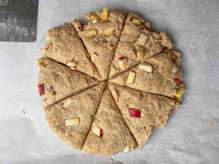 sourdough scone dough with apples in the shape of a disk with eight slices cut out