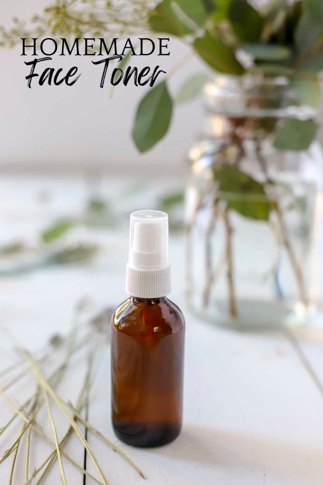 amber bottle of homemade face toner on a white countertop with eucalyptus in a jar in the background