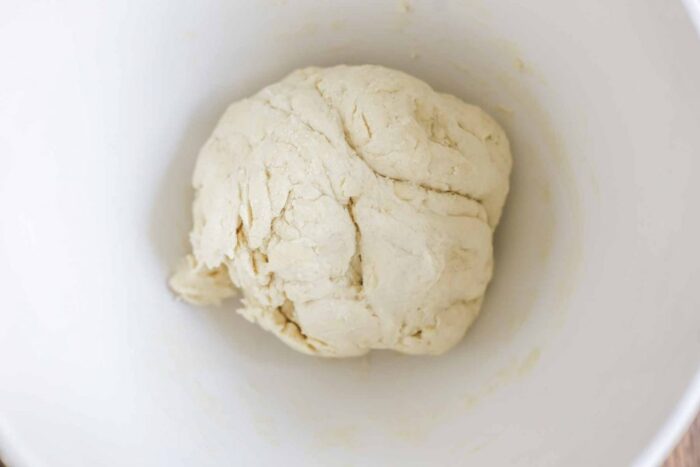 sourdough flatbread dough kneaded in a white ceramic stand mixer bowl