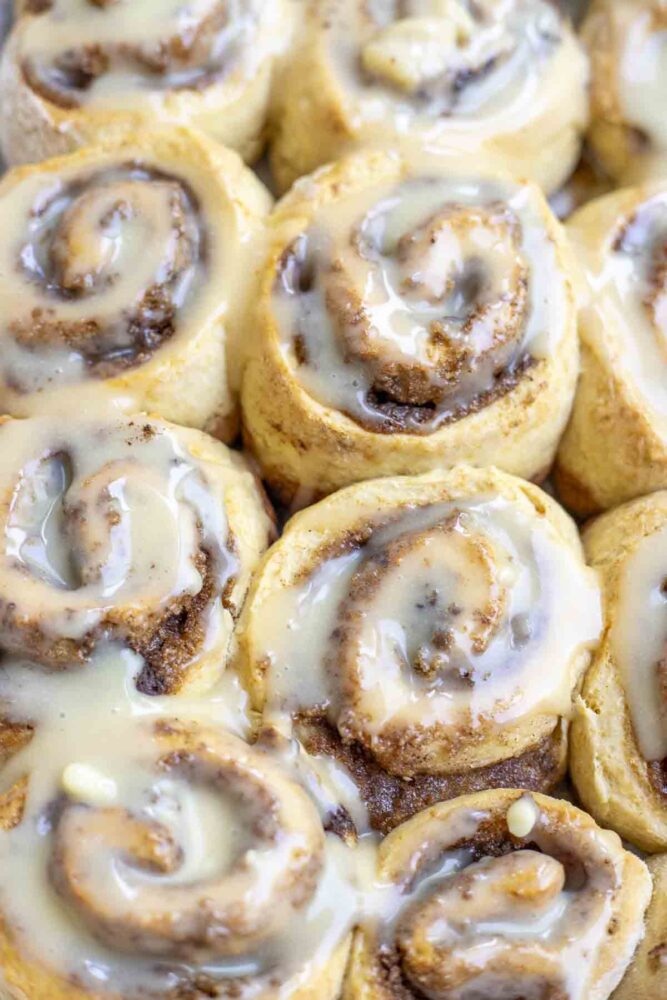 close up picture of sourdough discard cinnamon rolls topped with frosting.