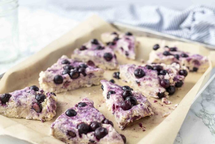 unbaked sourdough blueberry scones in parchment lined baking sheet.