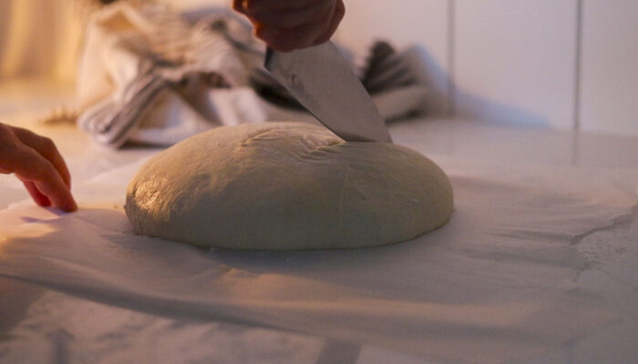 knife scoring the tope of a boule.