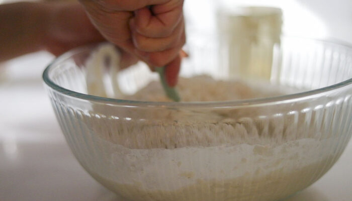 Mixing ingredients together in a glass bowl.