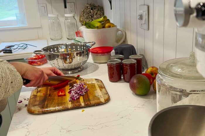 chopping onions and peppers on a cutting board.