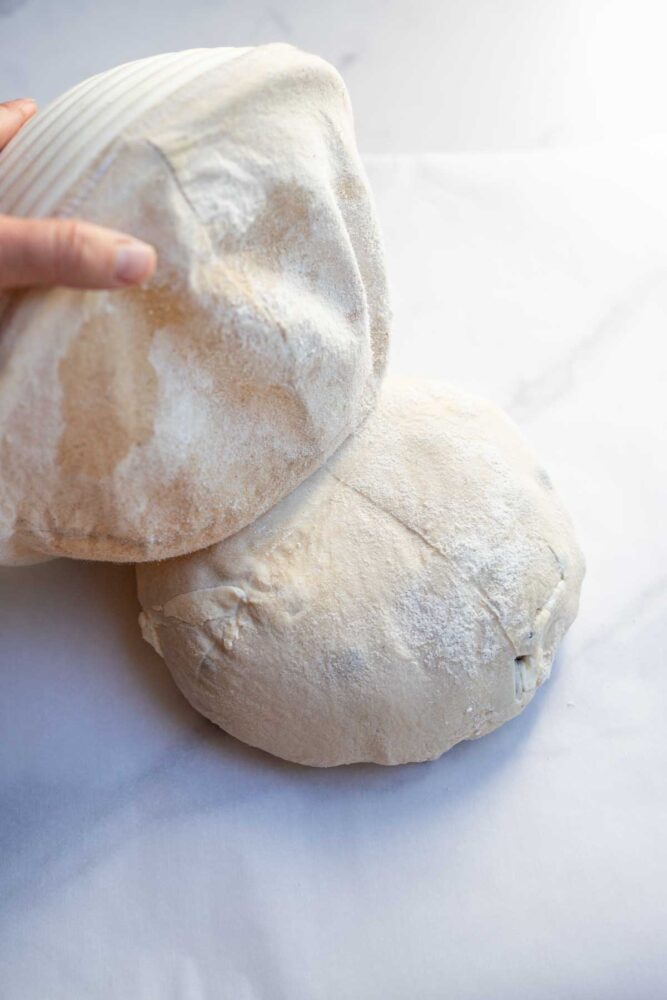 Turning bread dough out  onto a countertop.