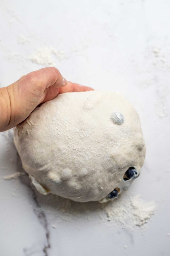 Creating tension in bread dough on a countertop.