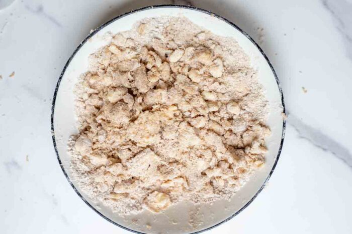 Butter added to dry ingredients in a bowl.