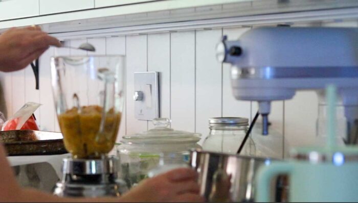 Adding peaches, lemon juice and a sweetener to a blender.