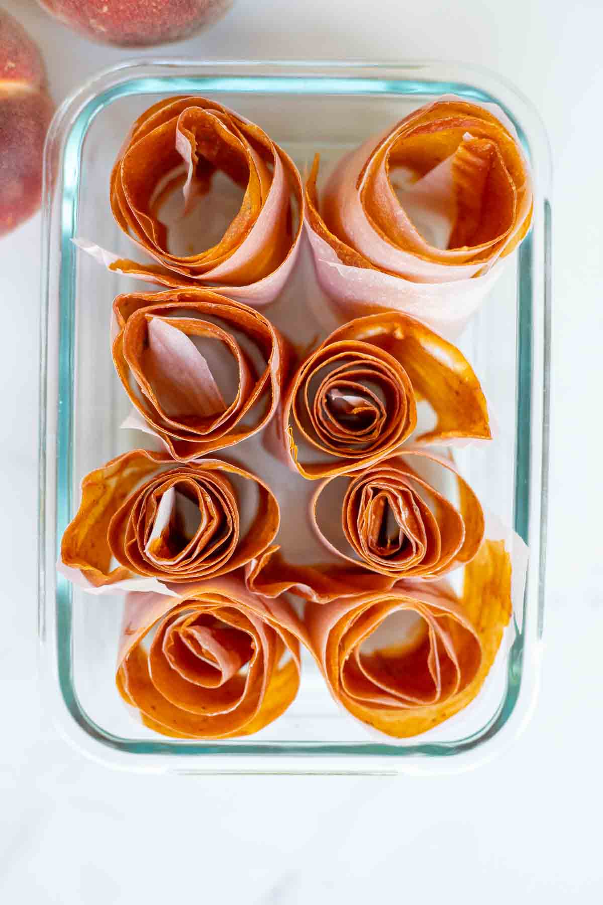 Peach leather rolled up and placed in a glass container.