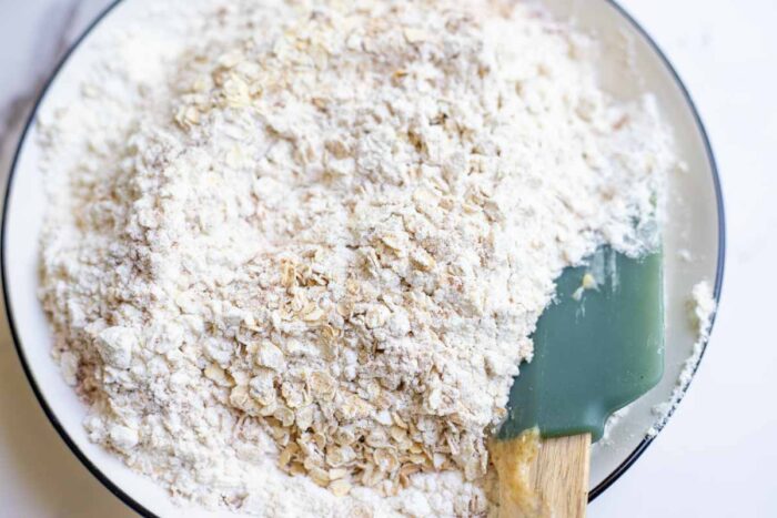 oats, flour, and leavening agents mixed together in a bowl.
