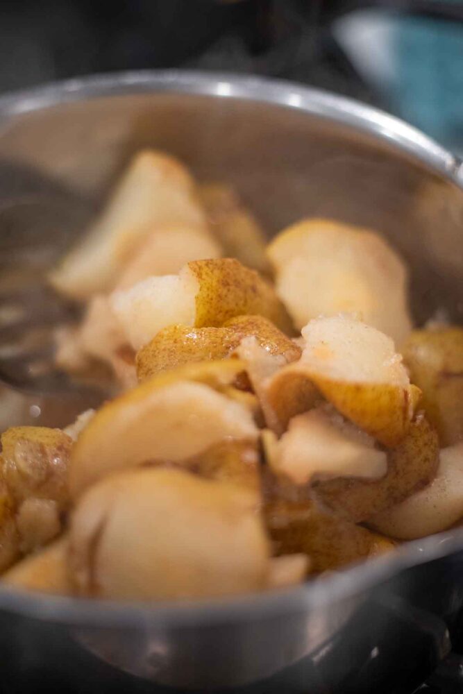 Pears cooked in a saucepan until soft.