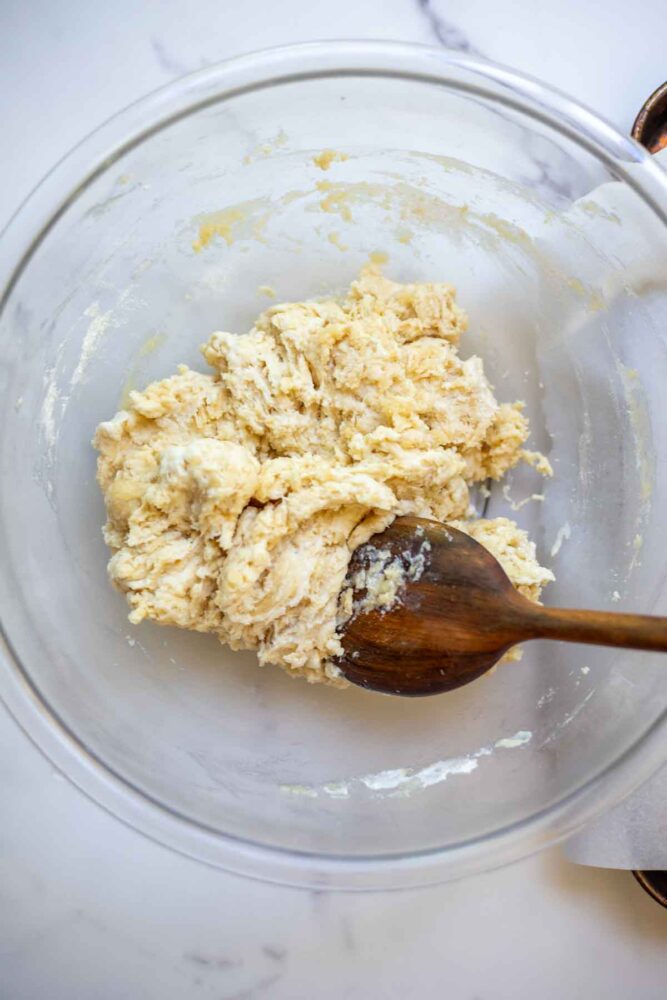Sourdough drop biscuit dough mixed together in a glass bowl.