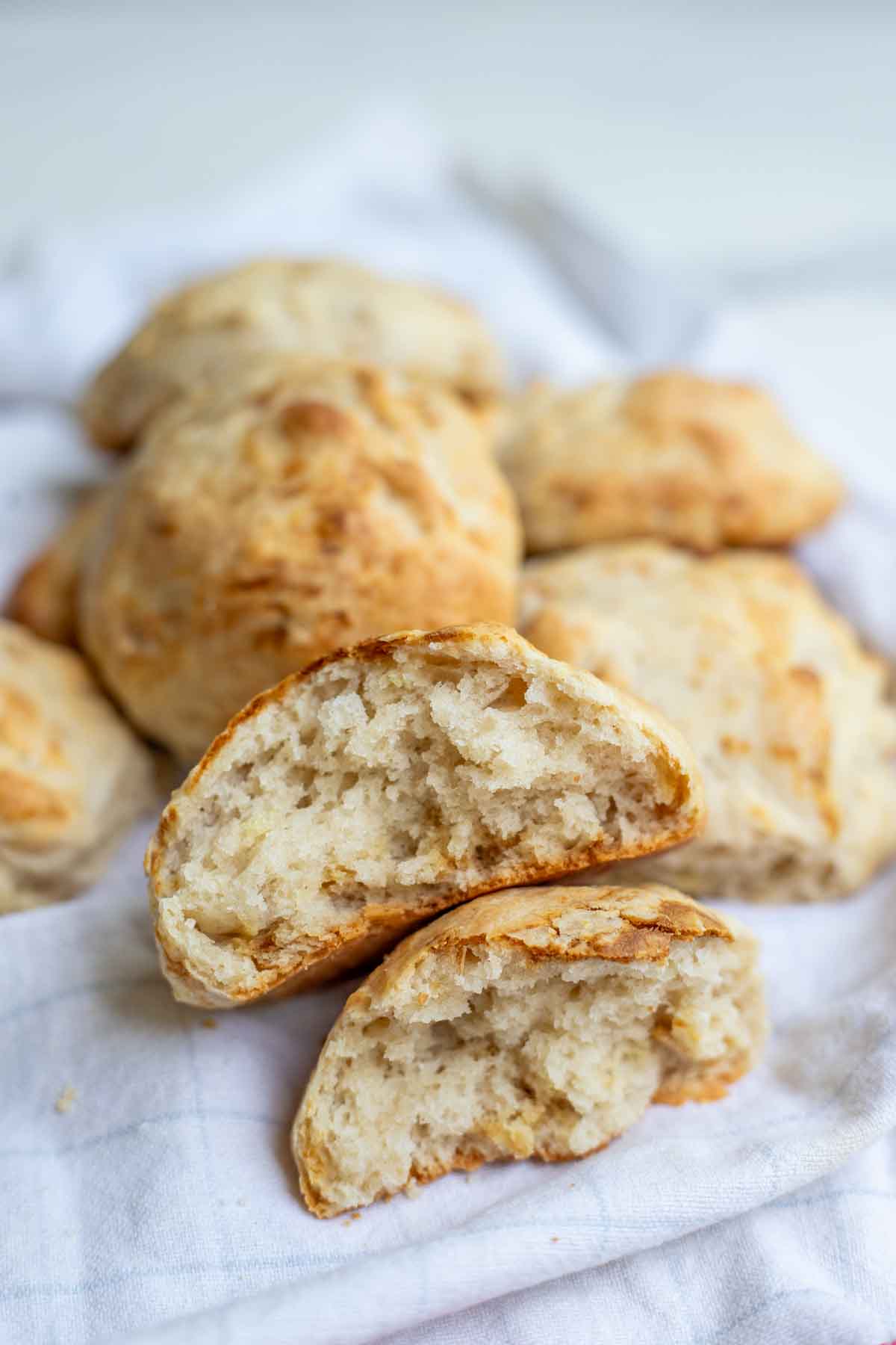 Sourdough drop biscuit cut in half and stacked on top of the other half. More biscuits are in the background.
