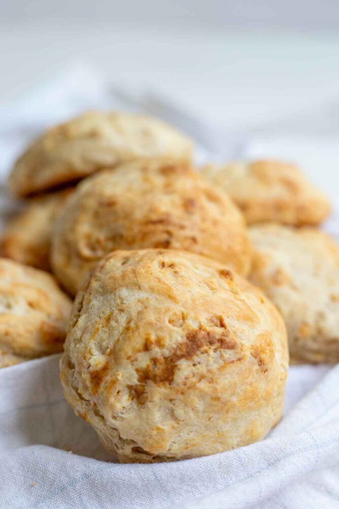 Sourdough drop biscuits spread out on a tea towel with a close up of one biscuits.