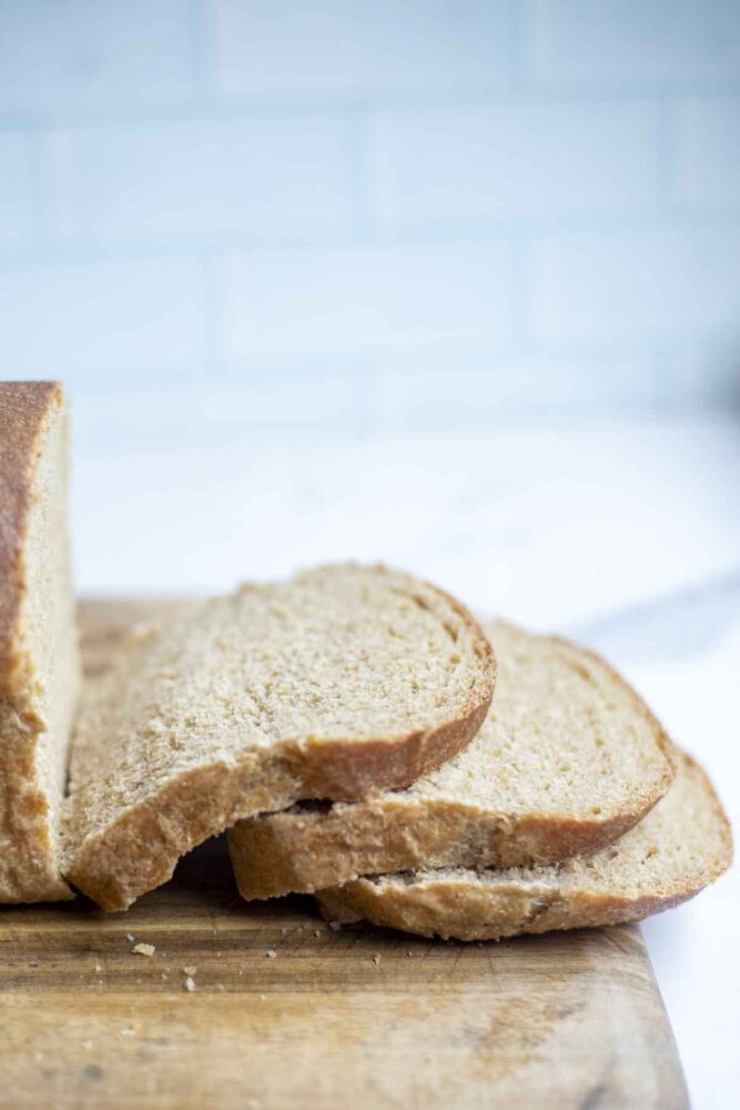 slices of whole wheat sourdough sandwich bread on a cutting board.