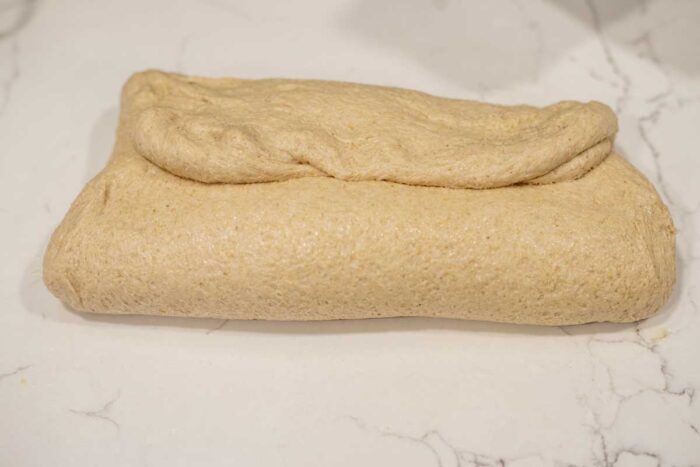 shaping bread dough on a countertop.
