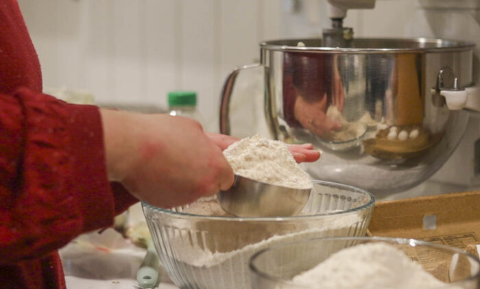 Adding dry ingredients to a bowl.