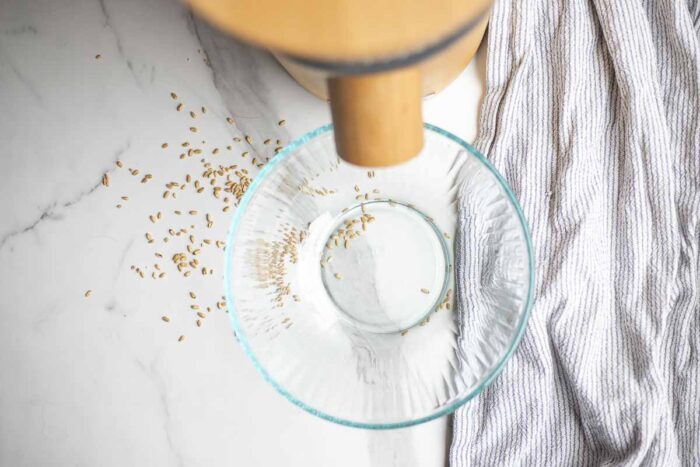 Setting up a grain mill with a bowl underneath.