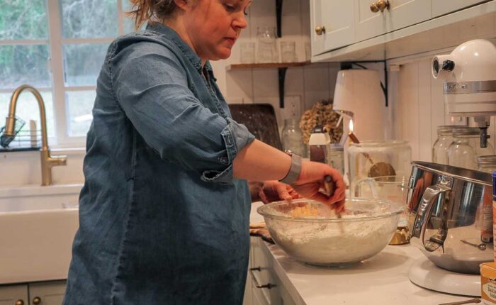 Mixing dry ingredients in a glass bowl in a kitchen.