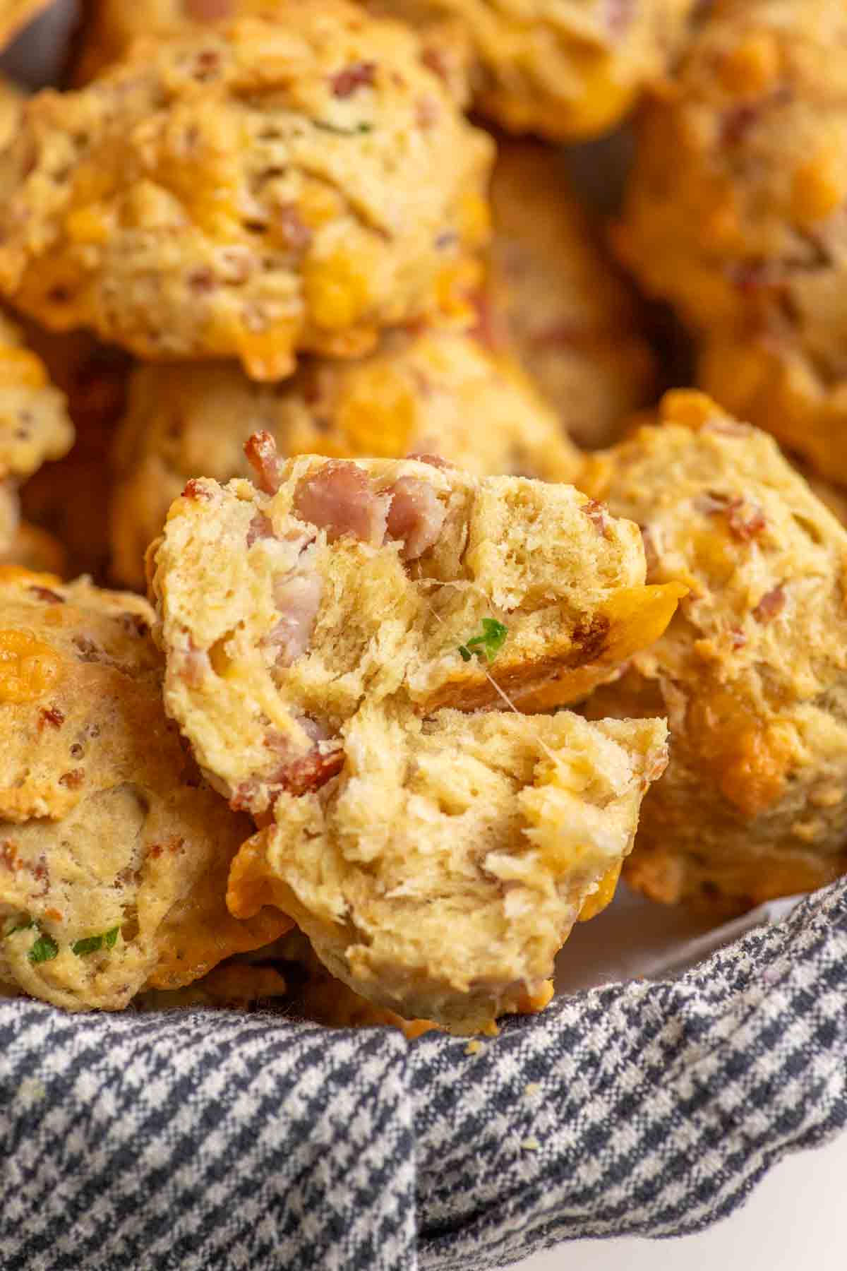 Breakfast biscuit cut in half showing the fluffy interior. The biscuit is in a basket full of biscuits.