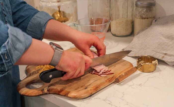 Dicing ham on a cutting board.